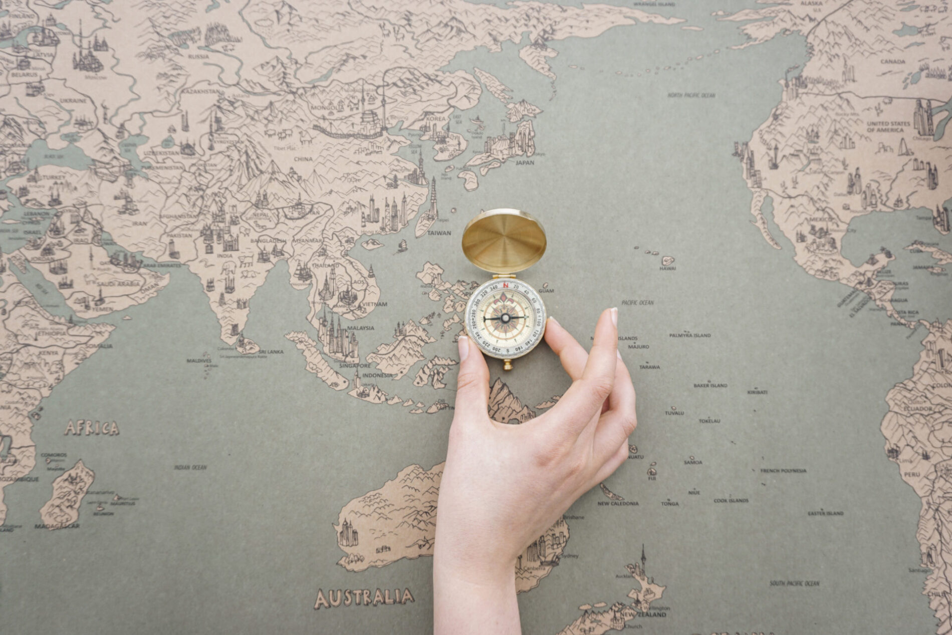 hand placing compass world map