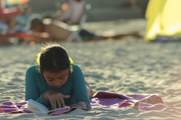 ragazzina che legge sulla spiaggia